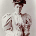 Photograph of Edith Wharton (author) sitting with two dogs.
