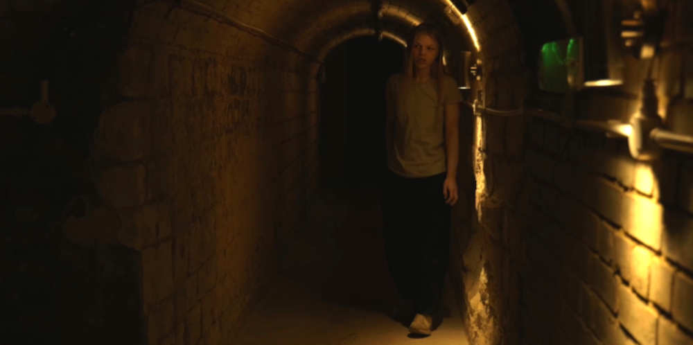 Abigail (Meghan Adara) trying to escape the cellar.